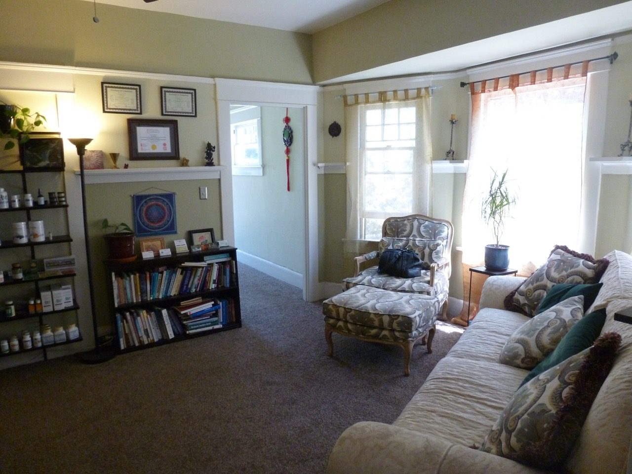 A living room with a couch, chair and bookcase.