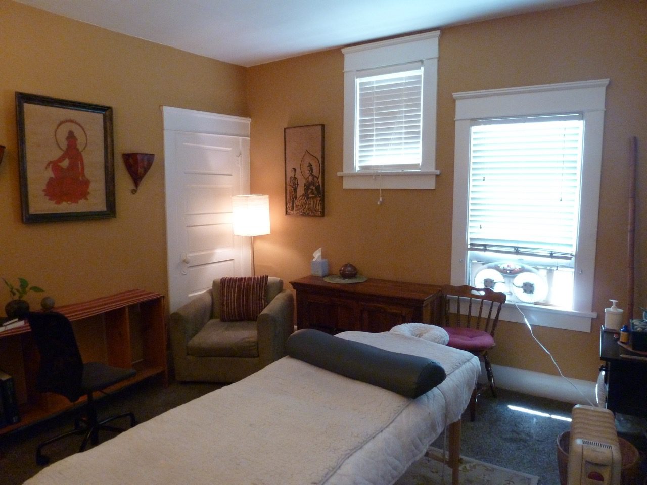 A bedroom with a bed, desk and chair.